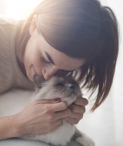 Woman hugs her cat after visiting State of the Heart Vet